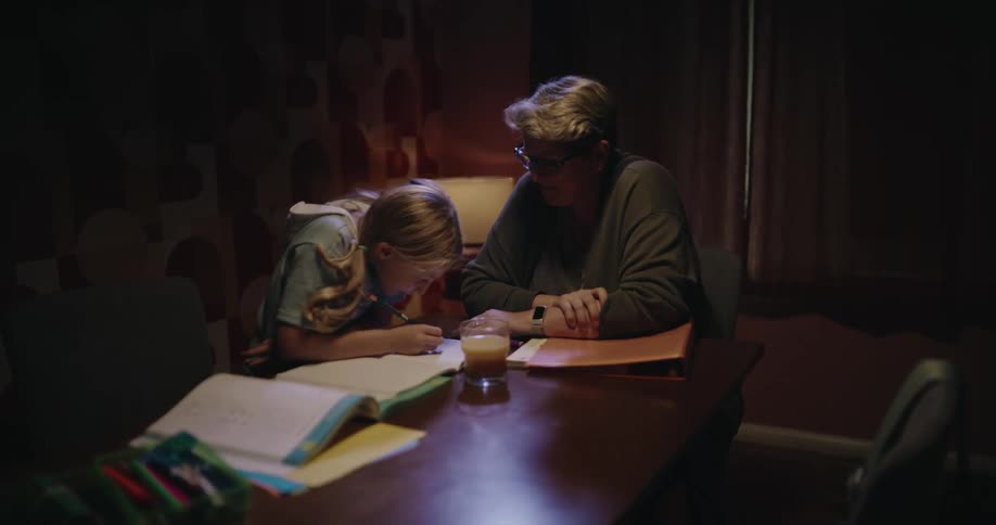 The grandmother helps her granddaughter study