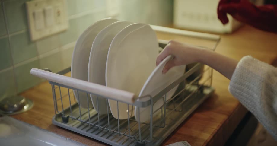 The mother and daughter high five after doing the dishes