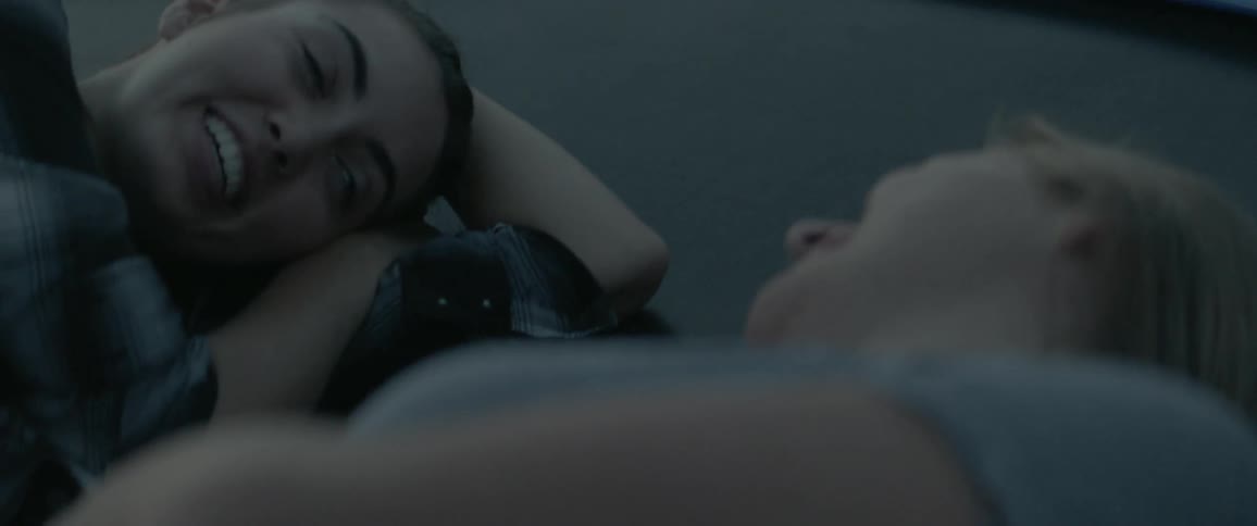 Two women chat while laying on a trampoline