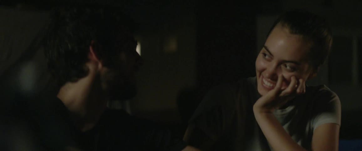 Woman talking and laughing with a man outside at night