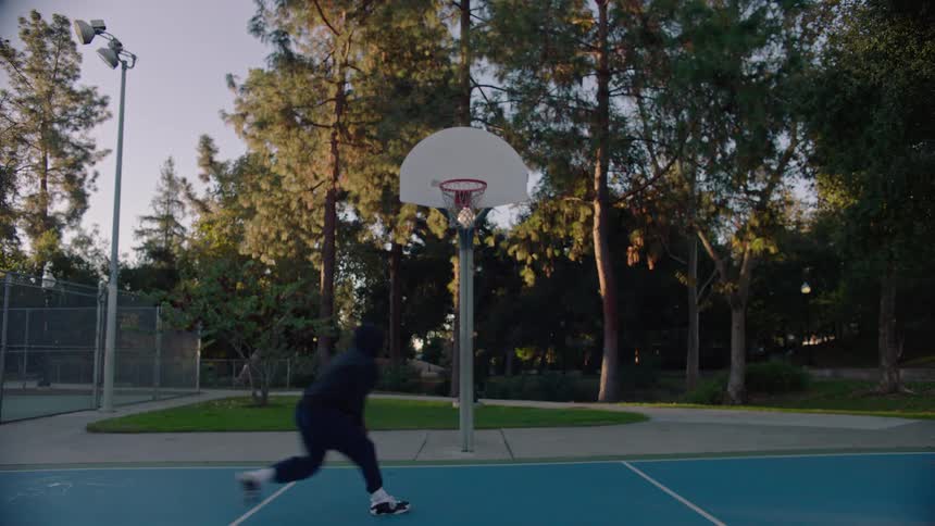 A man playing basketball outdoors