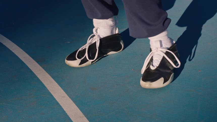 Black and white sneakers with futuristic design on blue basketball court