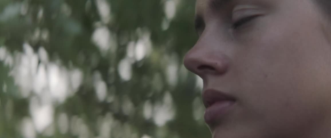 A woman standing outside by some trees