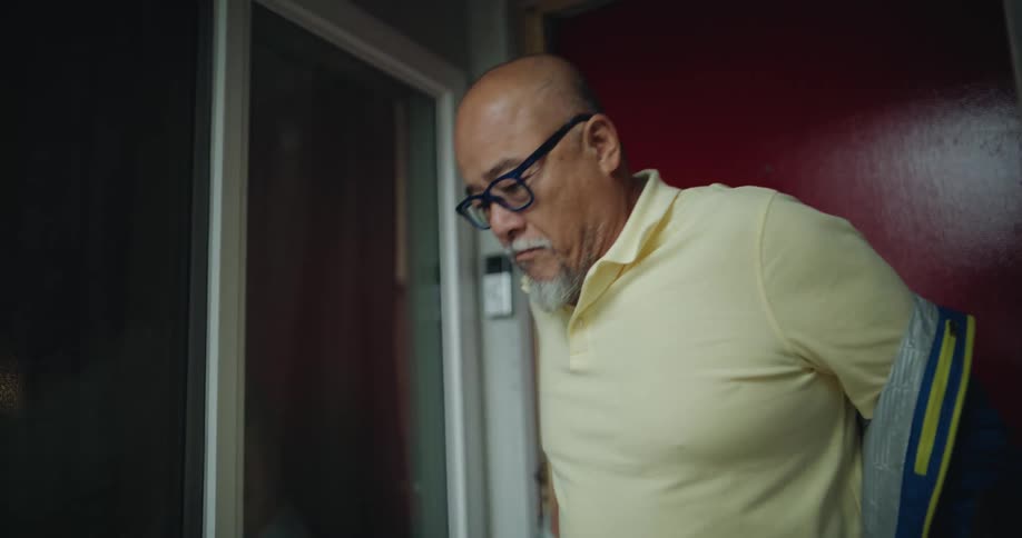 Man exits through the door wearing a jacket