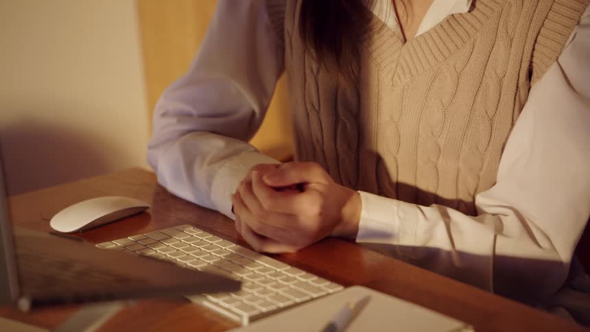 Close up of a young woman sitting at a desk while on a conference call with a laptop during daytime