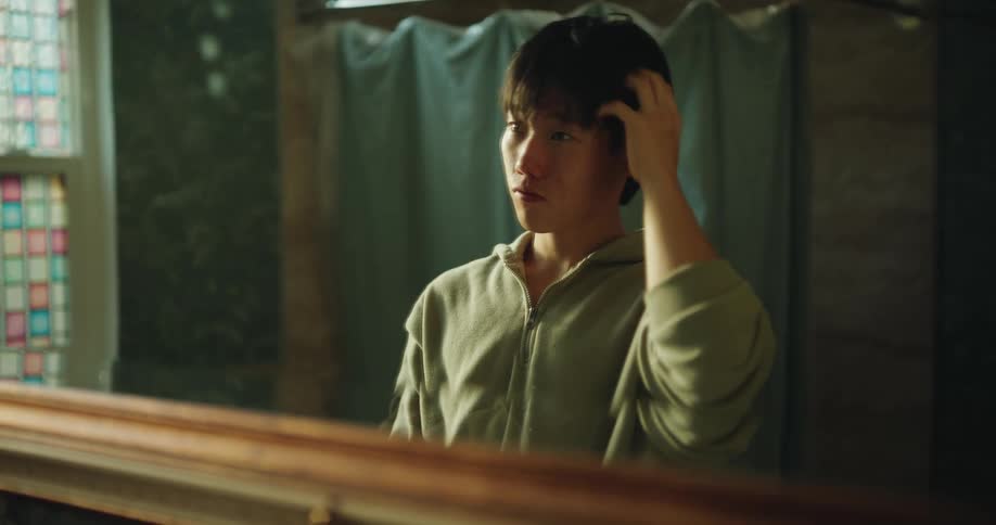 A portrait of a man looking into a mirror