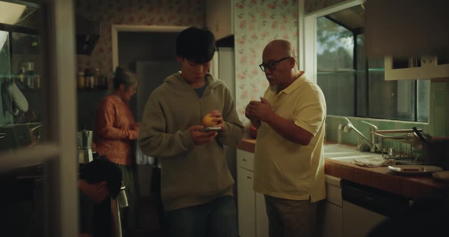 An asian family together in the kitchen as the children prepare to leave for school