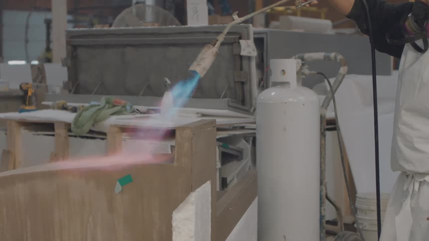 The worker is using a torch on the machine
