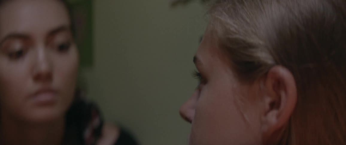 Two women gazing at each other before one leans in for a kiss