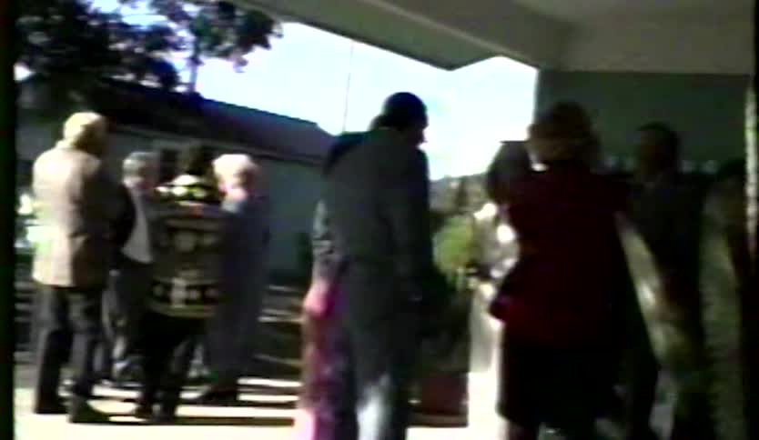 A group of people gather outside a building during a ceremonial event