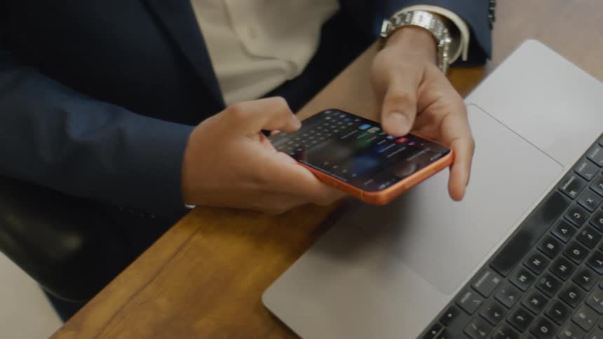 Hands hold and type on a smartphone