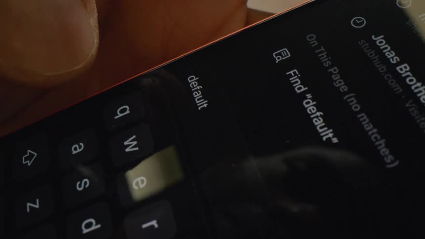 Mans thumb pushing keys on his phone keyboard with bankruptcy on the screen