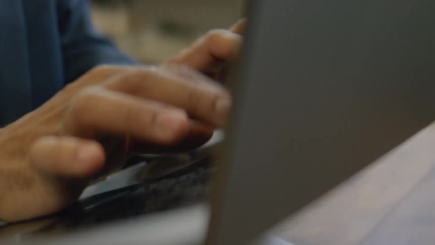A person typing on a laptop computer