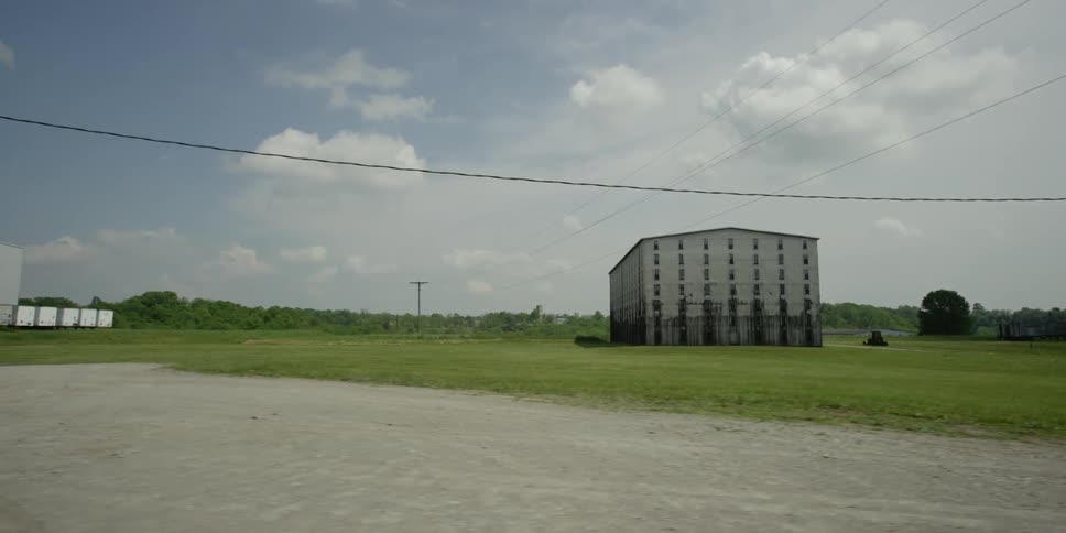 A building stands in a large grassy field