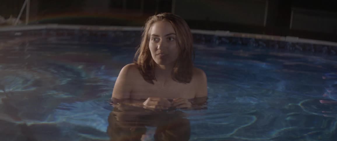 A naked woman turns around in a pool