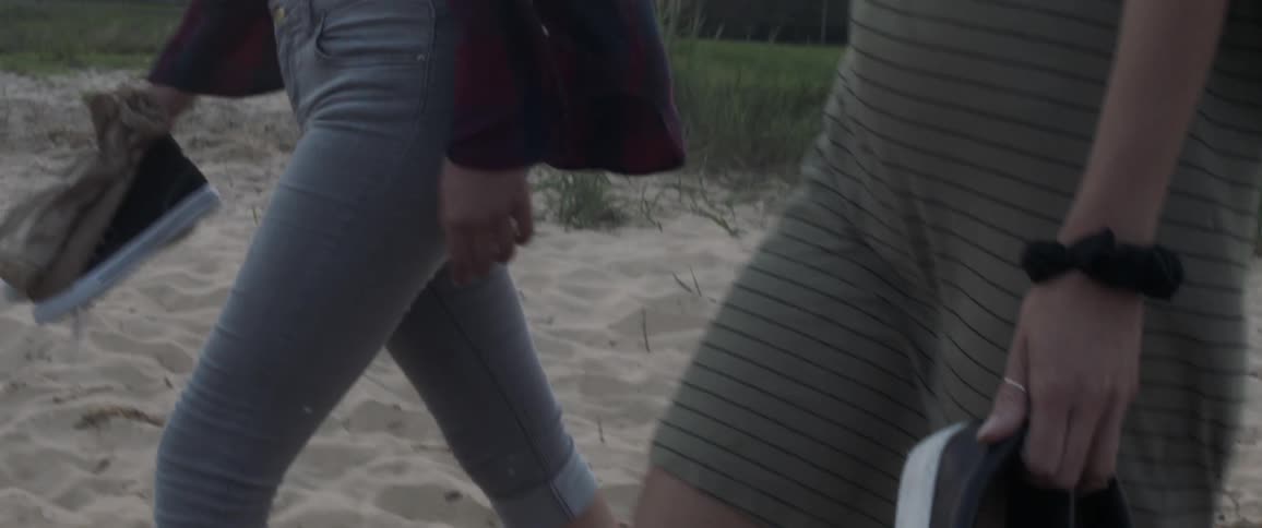 Two people walk in the sand