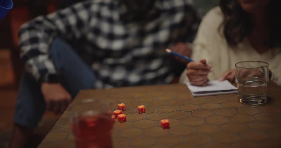 A happy family sits together playing a board game at a table in a cozy living room