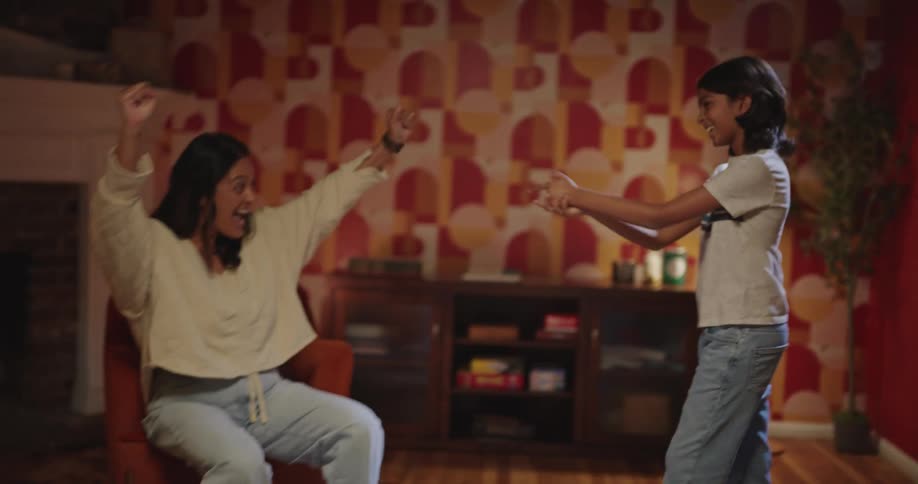 Team members high five while playing charades at home during game night