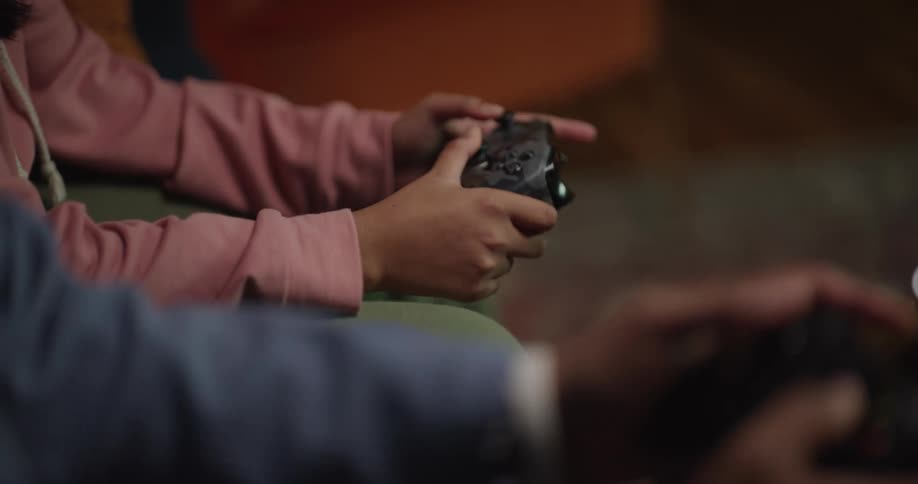 People are shown playing a video game with controllers with snacks and drinks nearby