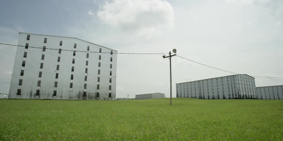 The green field leads to buildings ahead