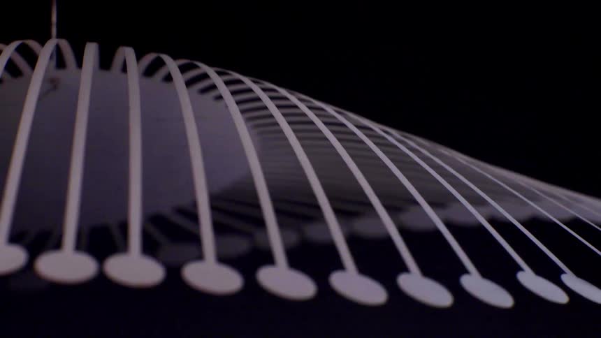 Parallel light lines with circular ends form a continuous curve over a dark background