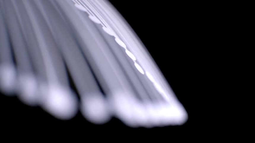 Closeup of glowing white streaks curving in an abstract pattern against a black background