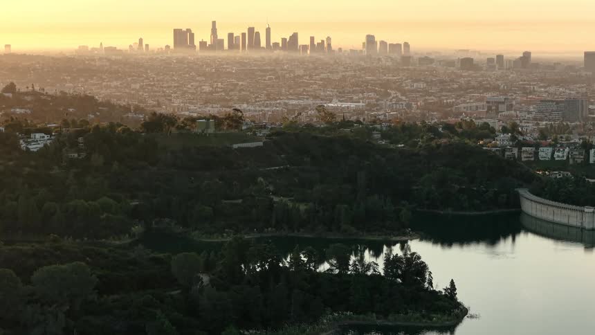 Reservoir reflecting sunset against urban grandeur