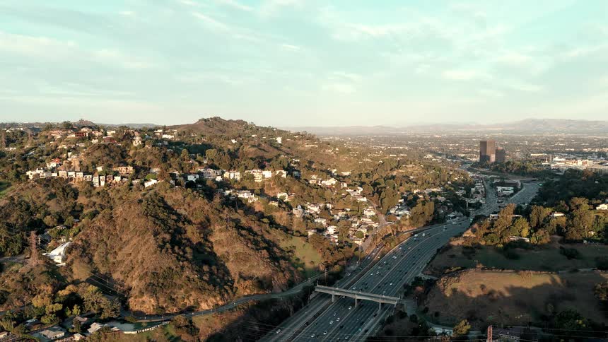 Busy highway cutting through urban area on hilly terrain