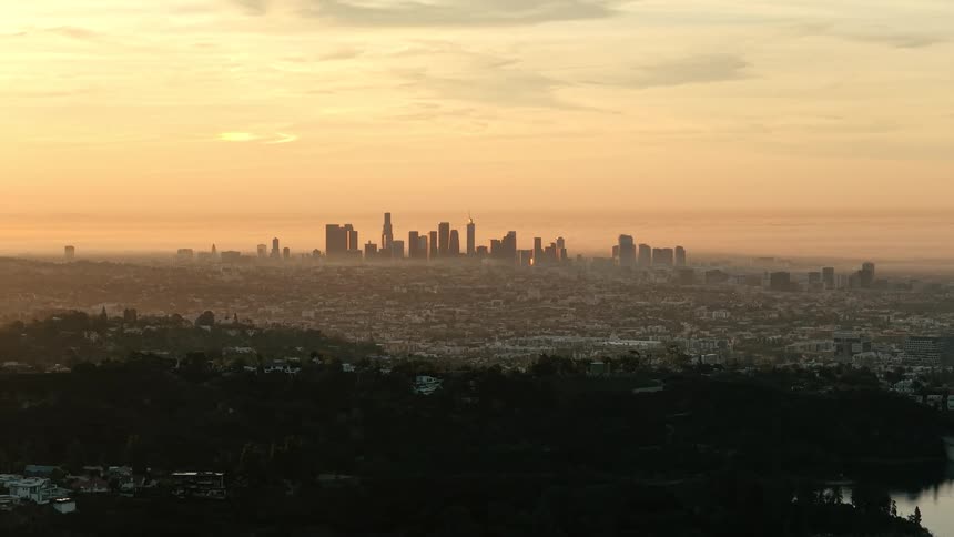 Aeriel view of crowded suburbs with towers and skyscrapers on the city skyline on the horizon