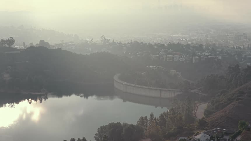 Waterfront of a river next to an urban area covered by haze outdoors