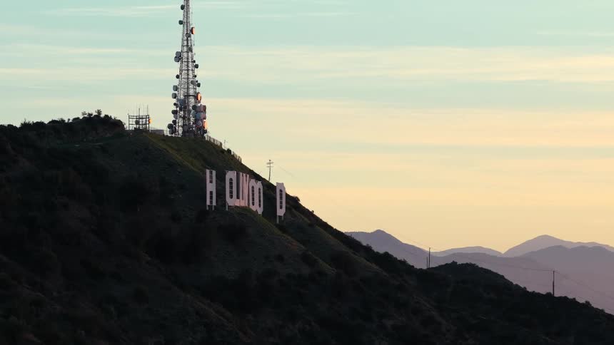 Letters spelling hollywood on a mountainside with a communications tower