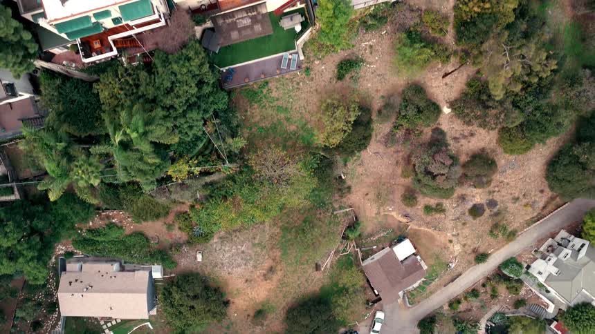 Aerial view moving over houses and streets with parked cars in a neighborhood