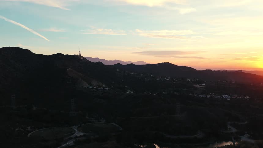 The sun is rising on the homes in the hills