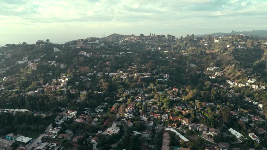Houses and buildings across the mountain as traffic moves on the streets