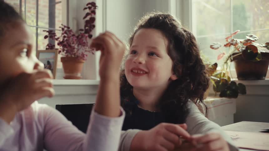 Two little girls sitting and talking