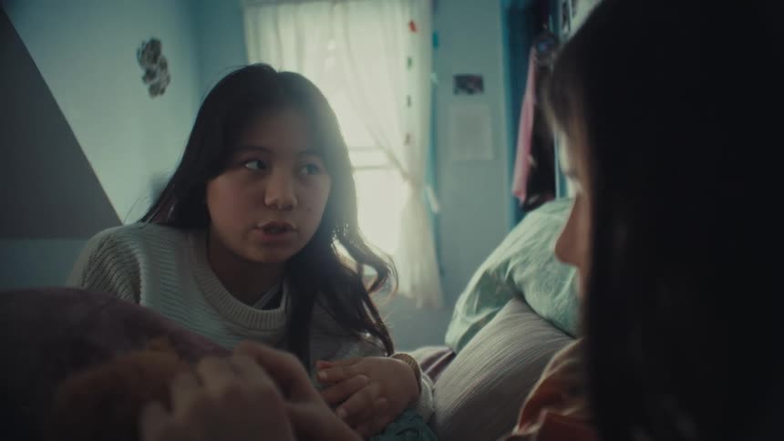 Two girls sitting on the bed talking