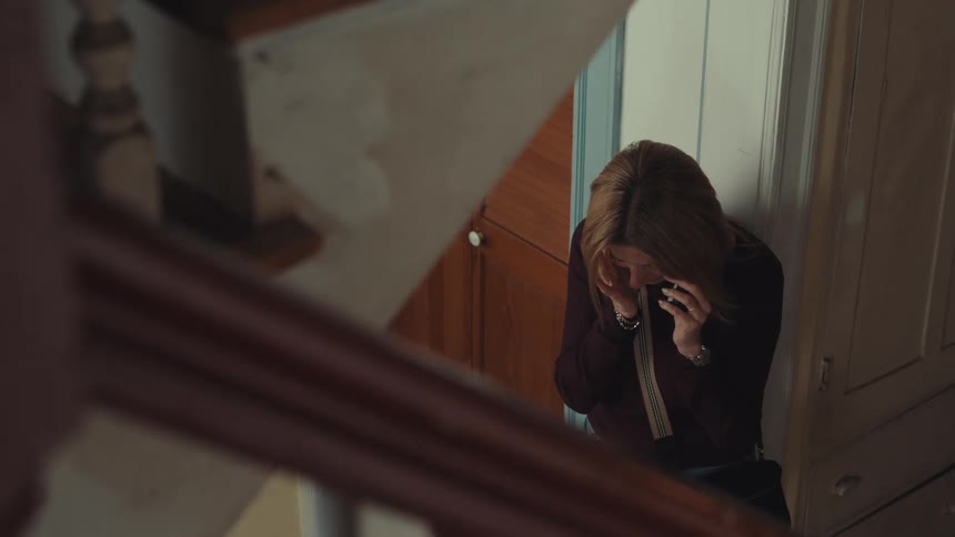 The woman hangs up her cell phone and cries