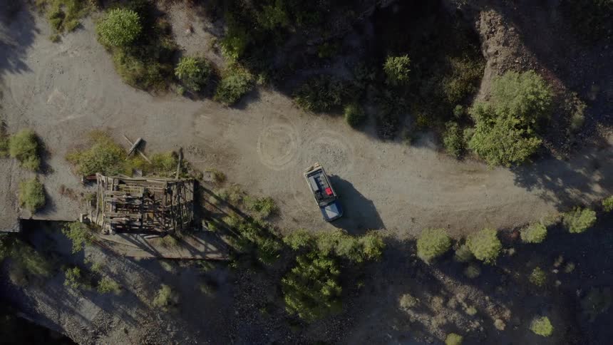 Vehicle stopped on a mountain trail next to a tower