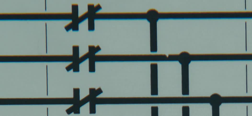 In a stark graphic closeup crisp black sharp symbols are precisely aligned on a series of parallel horizontal lines against a pale background