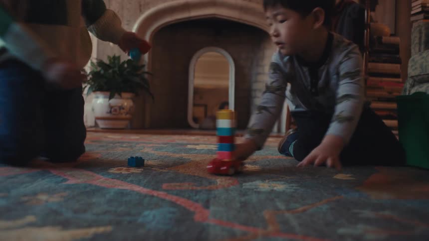 Two boys play with toys in the living room