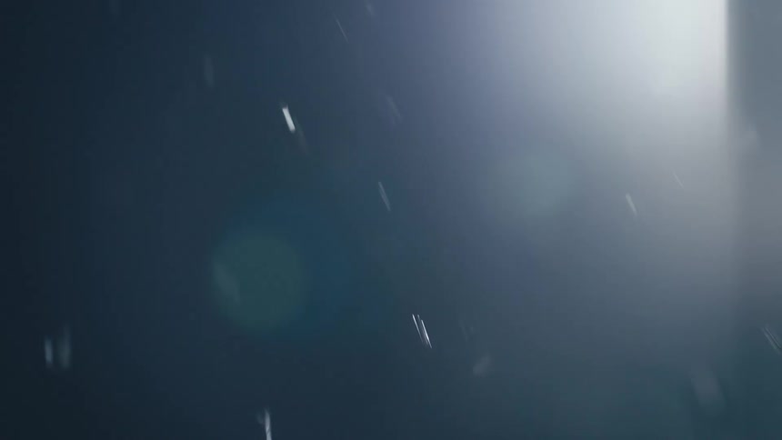 Translucent bubbles move through a liquid medium with diffuse bluish lighting