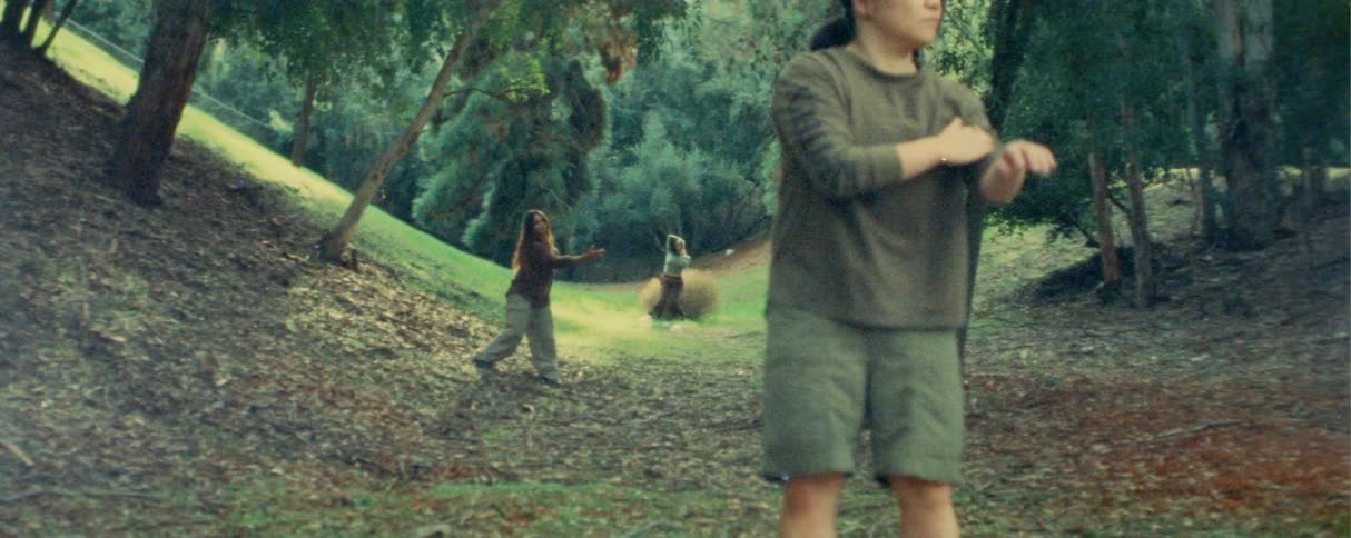 The three women are practicing tai chi in the grass