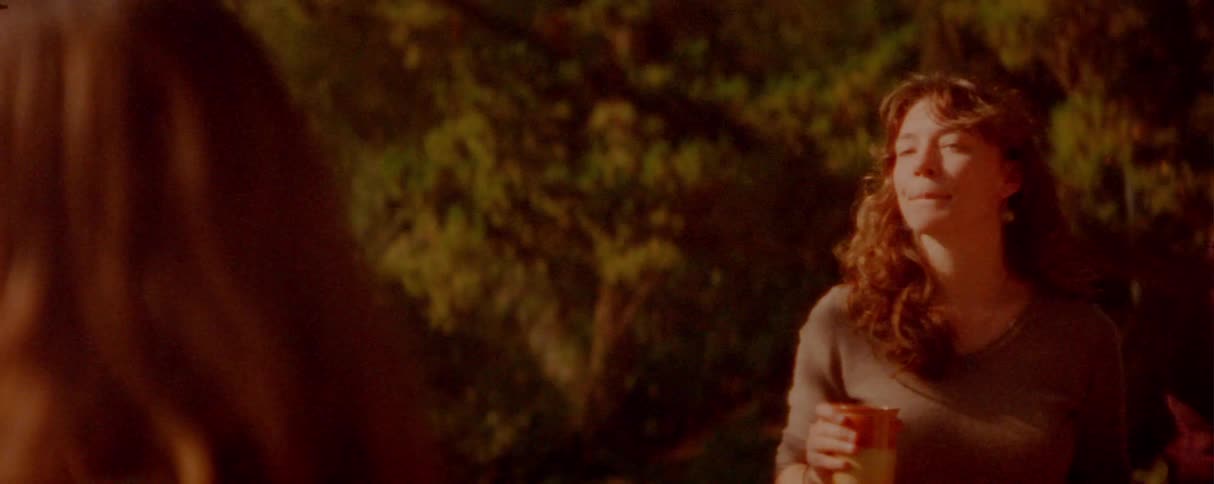 Two young couples stand in the woods at sunset each pair holding hands as they talk together in the warm fading light