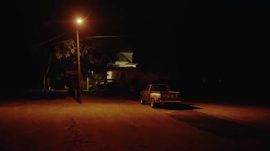 Truck parked on a road under a street light near buildings