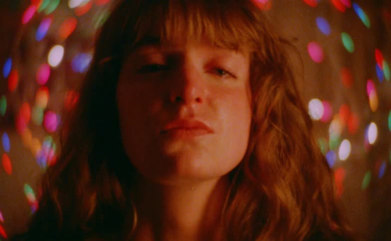 Close up portrait of a sad woman in a room decorated with disco lights