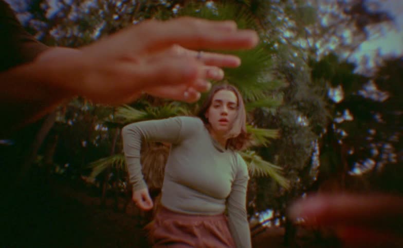 Woman dancing in front of a hand in the foreground