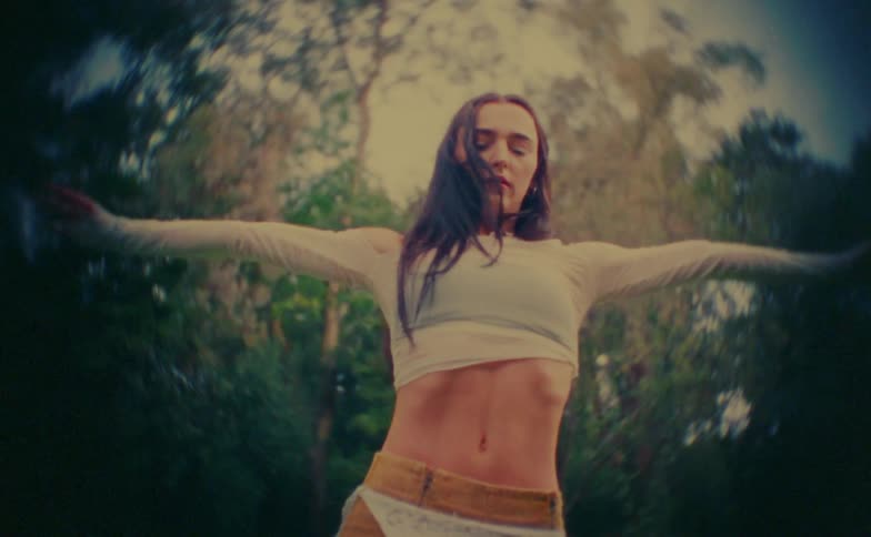 A woman dancing outdoors on a sunny day
