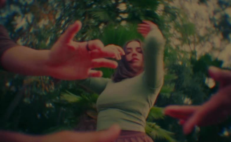 Woman dancing among the trees during the day