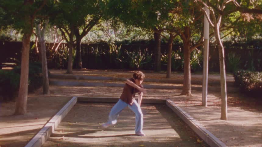 A young teenage male dancer dancing outdoors in a city during daytime