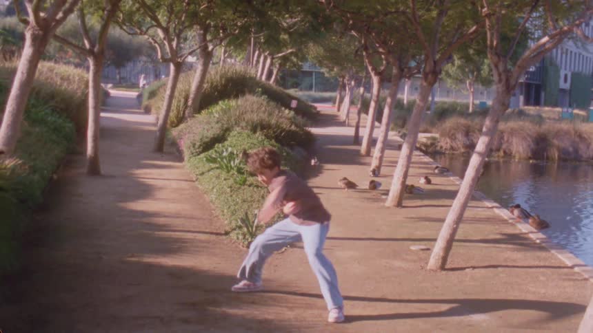 A man dancing outdoors near some trees